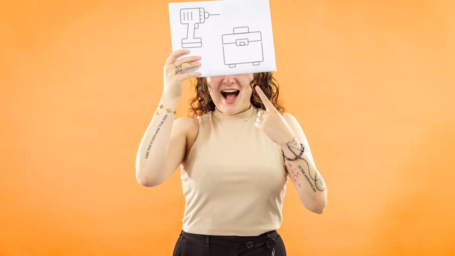 Personne qui tient une pancarte qui comporte des pictogrammes d'agent·e d'exploitation 