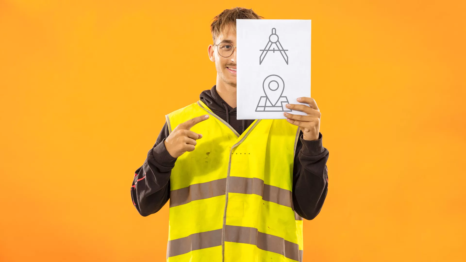 Personne qui tient une pancarte qui comporte des pictogrammes de dessinateur en architecture 