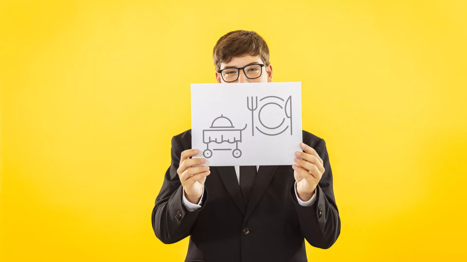 Personne qui tient une pancarte avec des pictogrammes d'employé en restauration