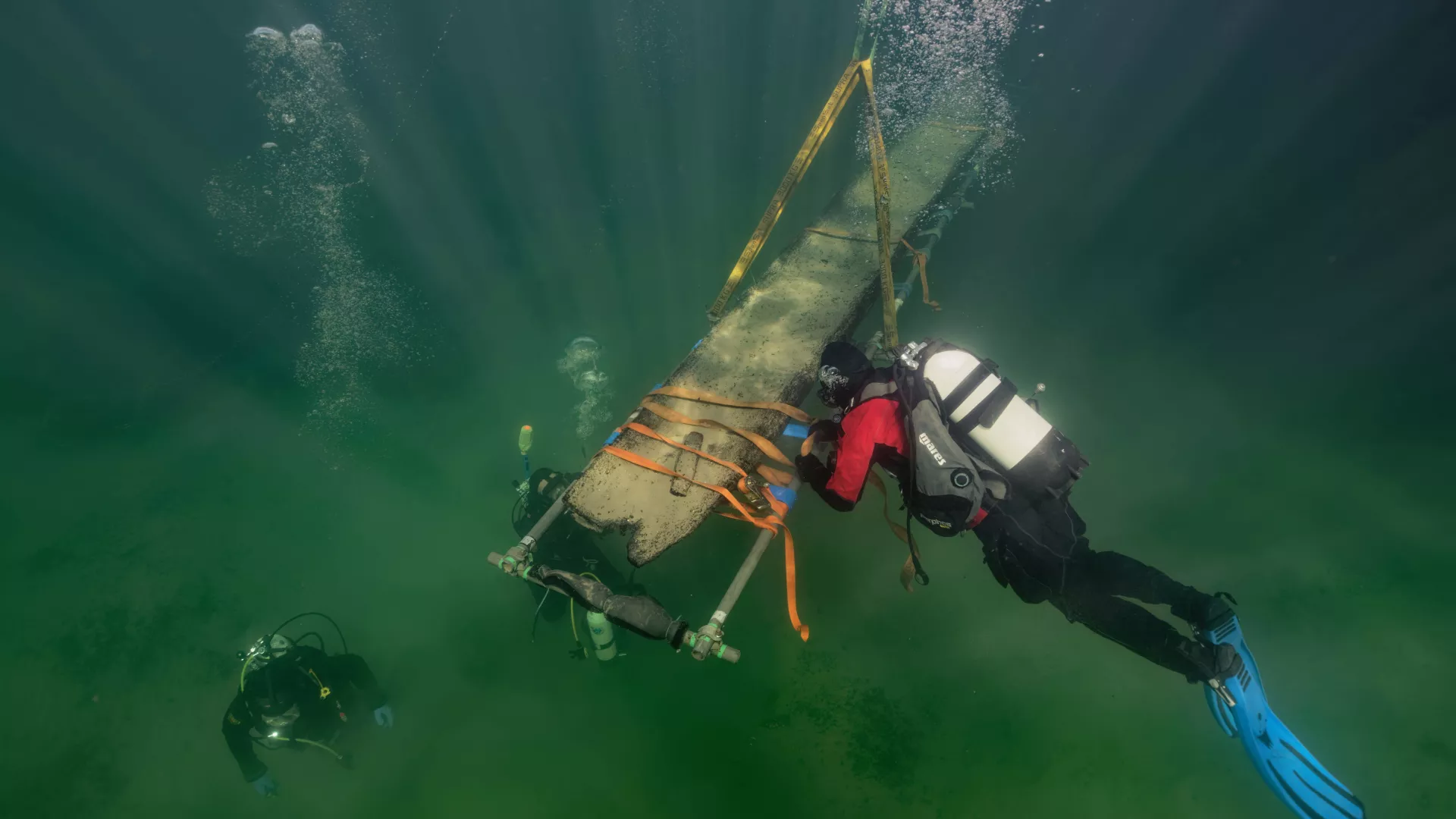 Des archéologues-plongeurs remontent une pirogue néolithique trouvée dans le lac de Neuchâtel, à Marin/Les Hauts Fonds