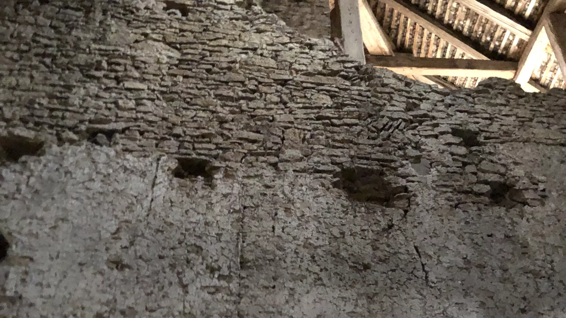 Détail d'un mur décrépi avec des maçonneries différentes et des trous de boulin