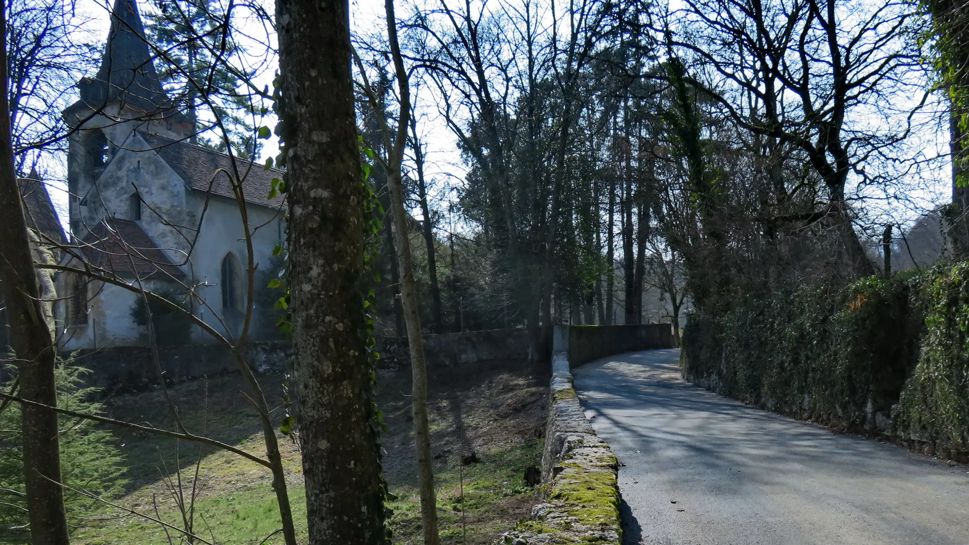 Vue d'une route historique avec murs anciens et église en arrière fond