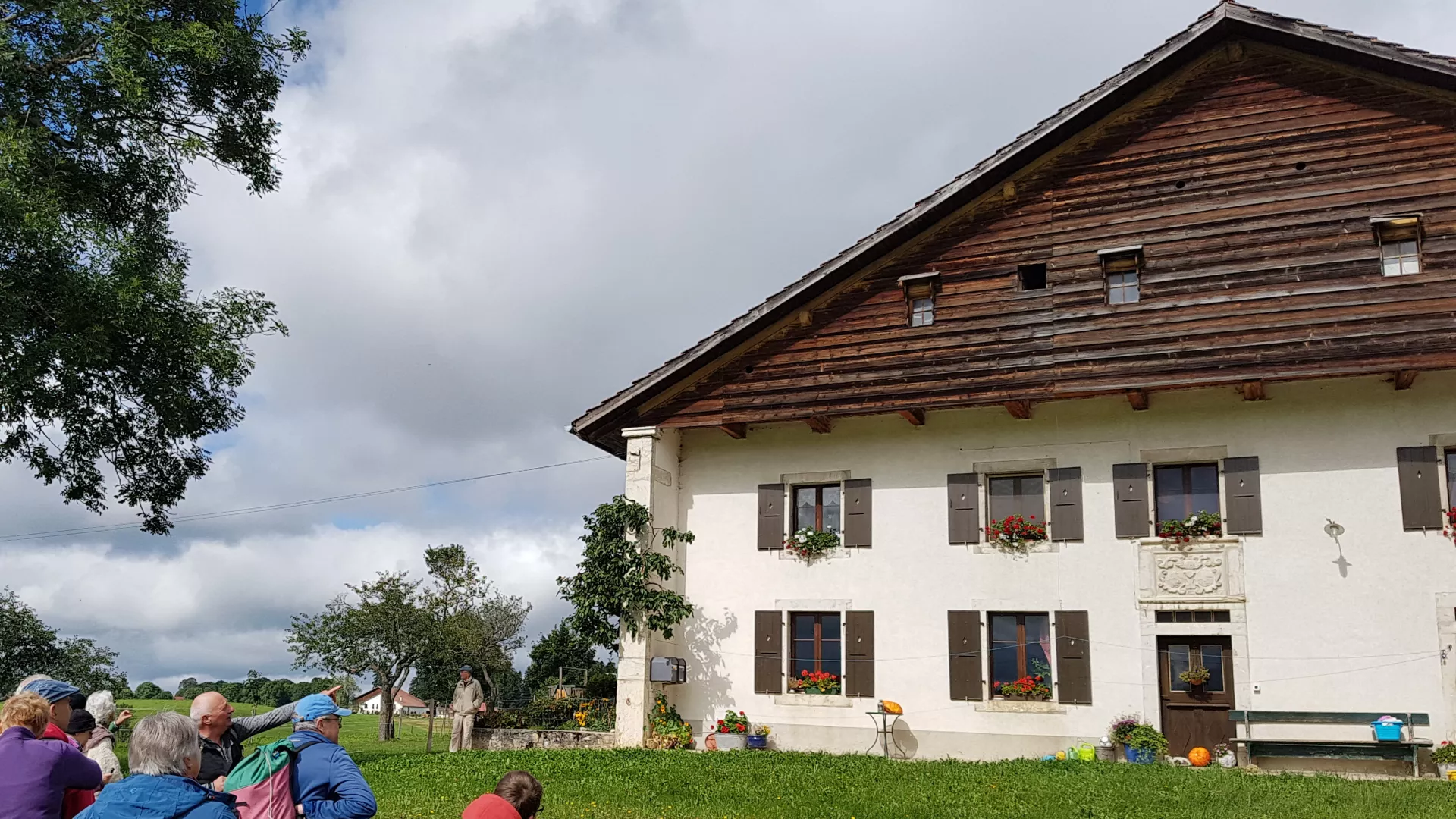 Guide donnant des explications à propos d'une maison paysanne des Montagnes neuchâteloises