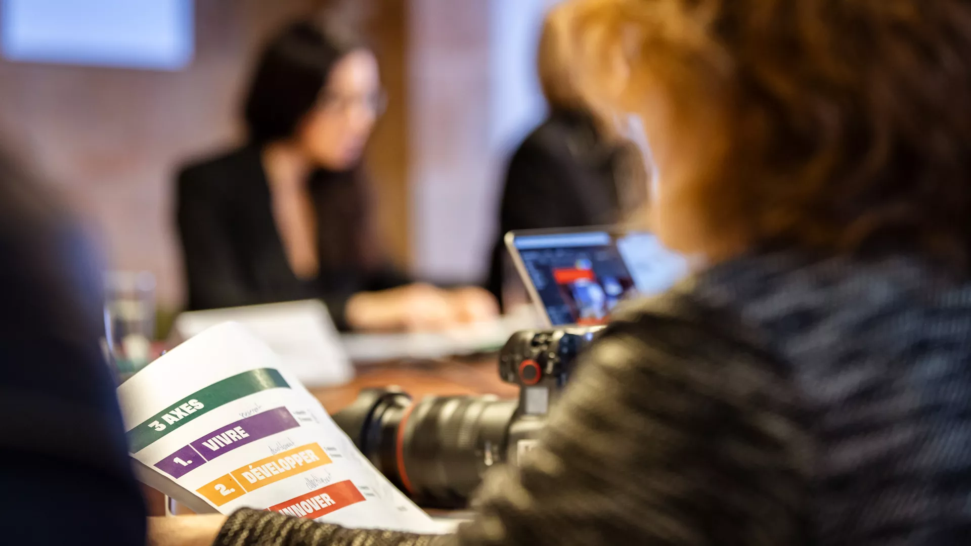 Une journaliste tient en main le programme de législature 2026-2029