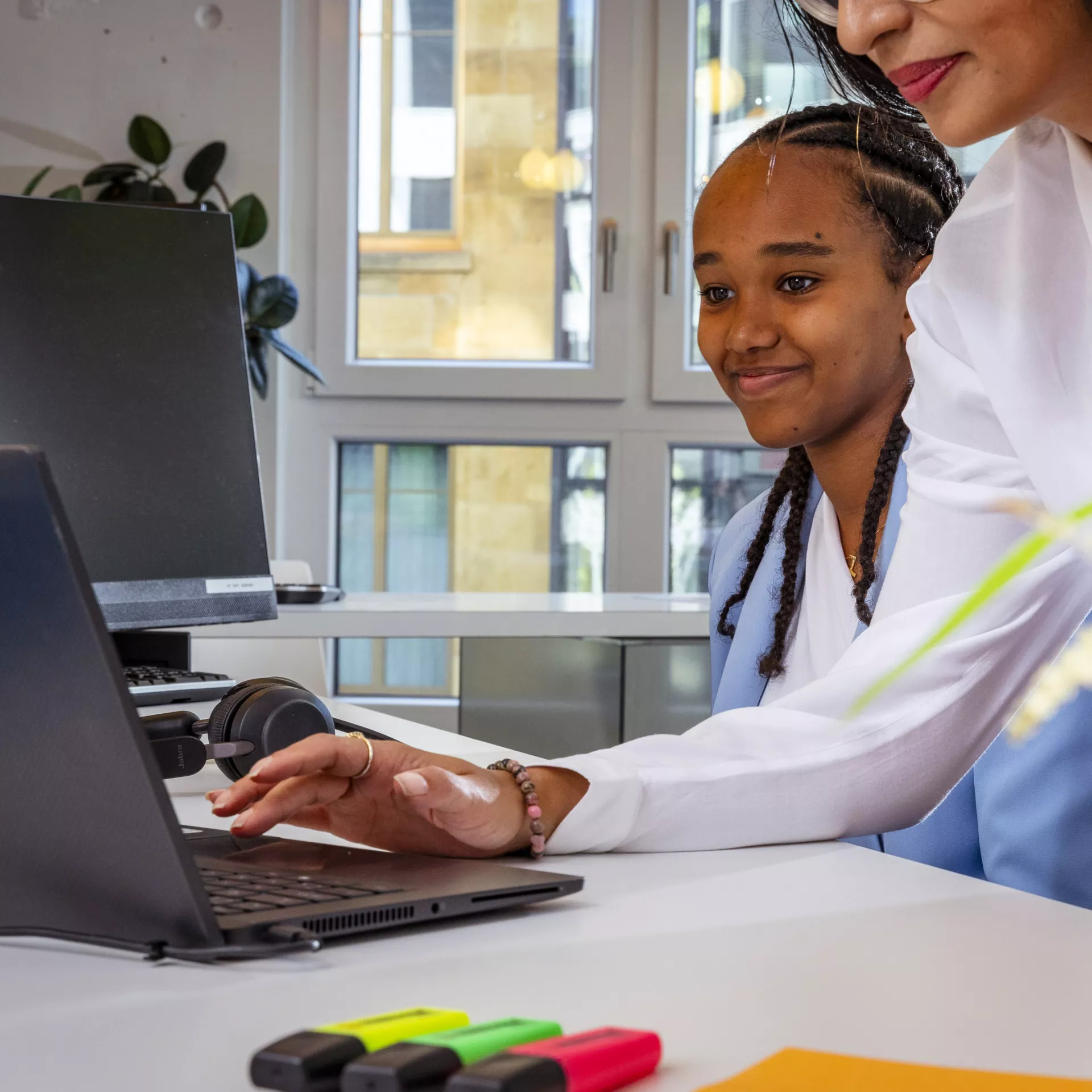 Personne qui explique à une autre des travaux sur un ordinateur