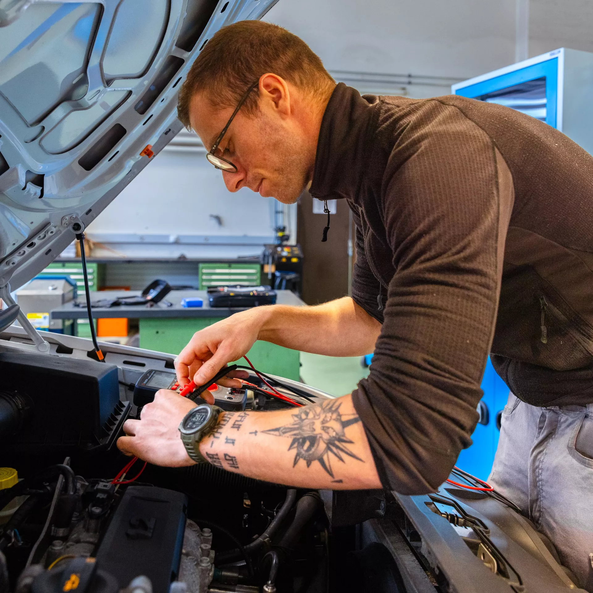 Personne qui travaille sous le capot d'une voiture